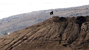 Eine IS-Flagge auf einem Hügel nahe der syrischen Stadt Kobane Foto: EPA