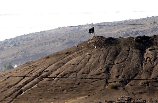 Eine IS-Flagge auf einem Hügel nahe der syrischen Stadt Kobane Foto: EPA