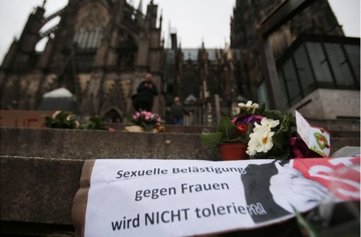 Blumen und Plakate erinnern in Köln an die Übergriffe auf Frauen in der Silvesternacht. Gegen 19 Männer ermittelt nun die Polizei. Foto: dpa