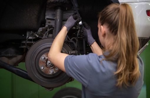 Eine Kfz-Mechanikerin wechselt in einer Werkstatt die Bremsscheibe eines Range Rover Evoque. Die berufliche Arbeitszeit von Frauen ist in der Corona-Krise im Schnitt stärker gesunken als die von Männern. Foto: Marijan Murat