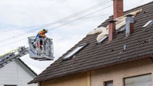 Mit einer Drehleiter zieht die Feuerwehr die Folie vom Dach. Foto: 7aktuell.de/Moritz Bassermann