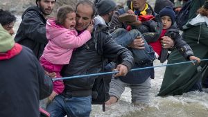 Hunderte Flüchtlinge versuchen am Montag, aus dem Lager bei Idomeni Richtung Mazedonien durchzudringen. Dabei waten sie durch einen Fluss. Weitere Bilder vom Montag zeigt die folgende Fotostrecke. Foto: AP