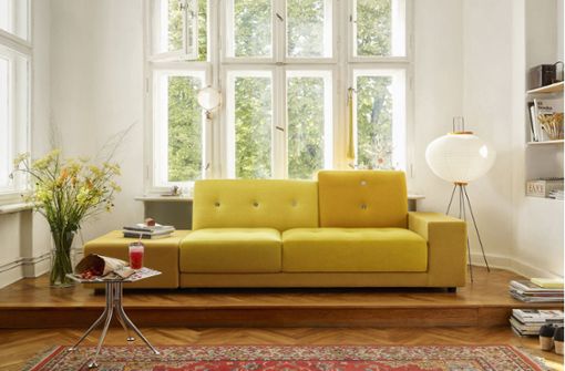 Die niederländische Designerin Hella Jongerius entwarf das  „Polder“-Sofa in fröhlichen Farben und asymmetrischen Kissen  für Vitra in Baden-Württemberg. Auf der breiten Armlehne und dem Hocker  ist Platz für Bücher und Computer. Foto: Hersteller/Vitra