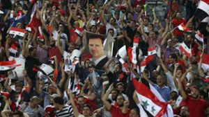 Anhänger der syrischen Nationalmannschaft jubeln im Azadi Stadium in Teheran über das 2:2 gegen den Iran. Ein Fan hält ein Porträt des syrischen Diktators Baschar al-Assad hoch. Foto: AP