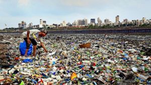 Ein Mann sammelt Plastik an der Küste des Arabischen Meeres. Die weltweite Diskussion über weniger Plastikmüll wird in Deutschland besonders stark geführt. Foto: dpa