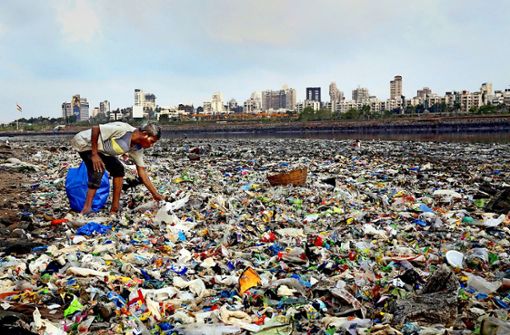 Ein Mann sammelt Plastik an der Küste des Arabischen Meeres. Die weltweite Diskussion über weniger Plastikmüll wird in Deutschland besonders stark geführt. Foto: dpa