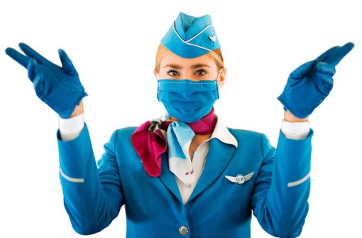 Auch das Flugpersonal muss Masken  tragen. Foto: Marius Becker/dpa-tmn