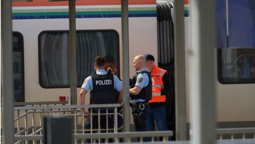 Bahnbedienstete und Polizeibeamte stehen am Bahnhof in Niederlahnstein vor einem Zug. In der Regionalbahn hat es einen Messerangriff auf einen Fahrgast gegeben, der schwer verletzt wurde. Foto: dpa/Thomas Frey