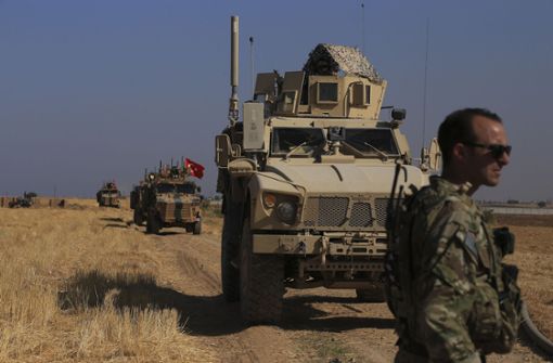 Türkische und amerikanische Panzerfahrzeuge patrouillieren bei der gemeinsamen Bodenpatrouille in der sogenannten «Sicherheitszone» auf der syrischen Seite der Grenze zur Türkei, nahe der Stadt Tal Abyad im Nordosten Syriens. Foto: dpa/Baderkhan Ahmad