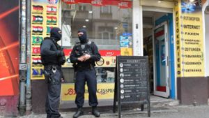 Einsatzkräfte stehen vor einem Kiosk im Stadtteil Neukölln. Die Berliner Polizei ist 2018 erneut gegen kriminelle arabische Großfamilien vorgegangen. (Symbolbild) Foto: dpa/Paul Zinken