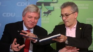 Der hessische  Ministerpräsident Volker Bouffier (CDU) und Grünen-Chef Tarek Al-Wazir unterschreiben den Koalitionsvertrag. Foto: dpa
