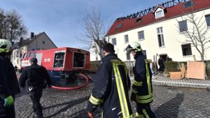 Der Dachstuhl ist ausgebrannt – Feuerwehrmänner vor der geplanten Unterkunft für Asylbewerber in Tröglitz Foto: dpa