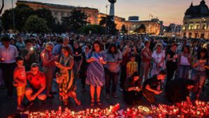Zahlreiche Menschen zünden im Gedenken an Alexandra vor dem rumänischen Innenministerium Kerzen für die ermordete 15-Jährige an. Foto: AFP