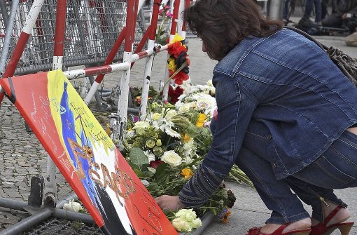 Vor der französischen Botschaft in Berlin legt eine Frau als Zeichen der Anteilnahme Blumen nieder. Foto: epd