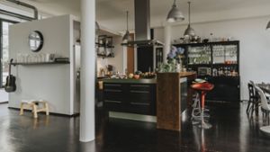 Eine Kücheninsel mit schwarzer Front und Holzelementen ist typisch für eine moderne Küche. Foto: imago/Mareen Fischinger