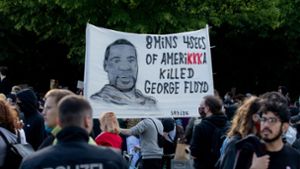 Ein Plakat mit dem Gesicht von George Floyd wird bei einer Kundgebung vor der US-Botschaft gegen den gewaltsamen Tod des Afroamerikaners durch einen weißen Polizisten in die Höhe gehalten. Foto: dpa/Christoph Soeder