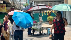 Menschen schützen sich in Bangkok mit Schirmen vor der extremen Hitze und vor der Sonne. Foto: Carola Frentzen/dpa