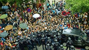In Barcelona hindern Einheiten der spanischen Nationalpolizei Menschen daran, zum Wahllokal zu gelangen. Vielerorts gelingt die Stimmabgabe dennoch. Separatisten stellen sich in Sant Julia de Ramis mit erhobenen Händen der Polizei entgegen. Foto: AP