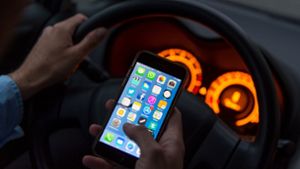 Handy aus der Hand und die Hände ans Steuer – das Smartphone muss im Auto in seine Halterung. Foto: dpa