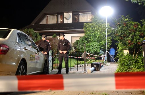 Polizisten stehen in der Nacht zum Donnerstag vor einem Haus in Hamburg-Schnelsen, in dem zuvor Schüsse gefallen sein sollen. Foto: dpa
