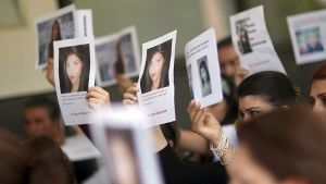 Angehörige und Freunde von Tugce trauern am im Juni 2015 vor dem Landgericht in Darmstadt nach der Urteilsverkündung und halten Bilder von ihr hoch. Foto: dpa