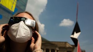 Zuletzt war am 10. Juni 2021 eine partielle Sonnenfinsternis zu beobachten: Eine junge Frau schaut auf dem Stuttgarter Schlossplatz durch eine Schutzbrille dem Himmelsspektakel zu. Foto: Lichtgut/Leif Piechowski