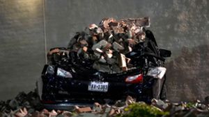 Ein Auto, das von herabfallenden Ziegeln einer umgestürzten Hauswand zerquetscht wurde, steht auf einem Parkplatz in der Innenstadt von Houston. Foto: David J. Phillip/AP/dpa