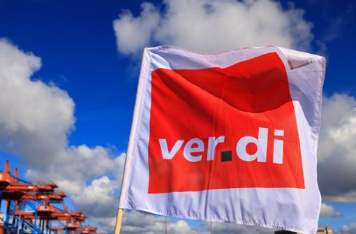 Eine Verdi-Flagge weht bei einem Warnstreik vor dem Container Terminal Burchardkai im Hamburger Hafen. (Archivbild) Foto: dpa/Christian Charisius