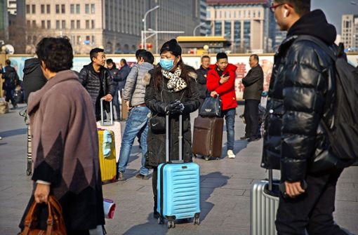Eine Reisende in Peking versucht, sich mit  Mundschutz vor der Infektion mit dem Coronavirus zu schützen Foto: dpa/Mark Schiefelbein