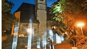 Die Lichtinstallation in Ditzingen betont die Treppe zur Konstanzer Kirche. Zwölf Lichtstrahlen ahmen die Form des Kirchturms nach. Foto: factum/Granville