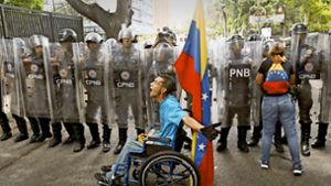 Ein Demonstrant beschimpft in Caracas Polizisten bei einer Demonstration für  den selbst ernannten Interimspräsidenten Guaidó. Foto: AP