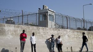 Eine Gruppe von Migranten steht an einer Mauer des Flüchtlingslagers Moria auf der Insel Lesbos im Ägäischen Meer. Foto: AP