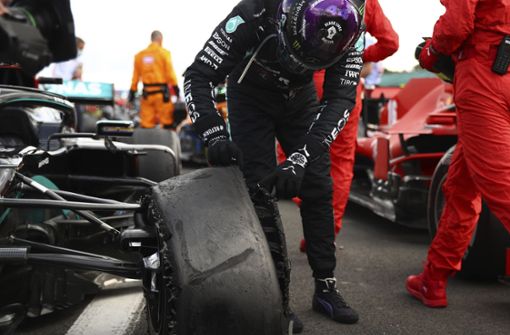 Da ist nichts mehr zu retten: Lewis Hamilton obduziert den linken Vorderreifen seines Silberpfeils – der Plattfuß hätte ihn beinahe den Sieg gekostet. Foto: AP/Bryn Lennon