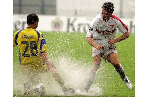 Auch der VfB Stuttgart hatte schon mit üblen Wetterverhältnissen zu kämpfen. Hier versucht sich Jesper Gronkjaer (rechts) bei der „Wasserschlacht“ von Domzale im Jahr 2005. Foto: dpa