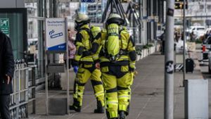 Feuerwehrleute betreten in Schutzanzügen das Flughafengebäude von Terminal 3. Foto: SDMG/Kohls