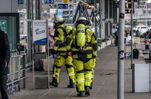 Feuerwehrleute betreten in Schutzanzügen das Flughafengebäude von Terminal 3. Foto: SDMG/Kohls