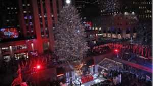 Die Dimensionen des imposanten Weihnachtsbaums am Rockefeller Center in New York lassen sich erahnen wenn man die winzigen Menschen vorne auf der Bühne während der Eröffnungsshow betrachtet. Foto: AP/Kathy Willens