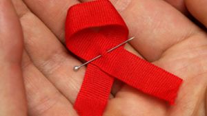 Die rote Schleife ist weltweit ein Symbol für die Solidarität mit Menschen, die HIV positiv sind. So wie Dieter Stammkötter, für den seit 60. Geburtstag ein kleines Wunder ist. Foto: dpa