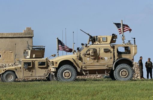 Zwei Fahrzeuge der US-Armee stehen vor einem amerikanischen Stützpunkt in der Nähe von Manbidsch in Syrien. Foto: AP