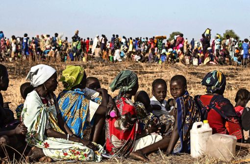 Kinder und Frauen  warten im Südsudan auf Hilfslieferungen. Hilfe in dem armen Land ist dringend notwendig. Foto: dpa/Modola