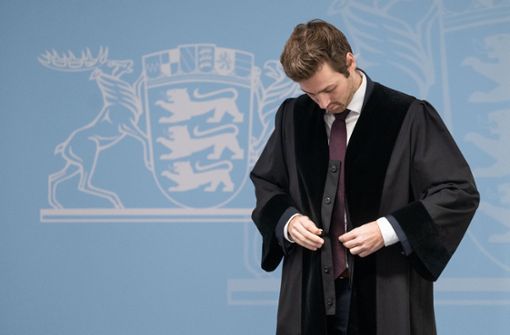 Timo Haußer, Vorsitzender des Landesverbands Baden-Württemberg des Bundes Deutscher Rechtspfleger, legt eine Robe an. Foto: dpa/Marijan Murat