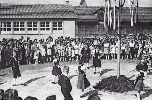 Kinder in Trachten tanzen 1950 um den ersten Maibaum der Egerländer Gmoi in Wendlingen. Foto: Festschrift 50 Jahre Egerländer Gmoi