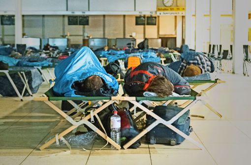 Reisende schlafen am Helmut-Schmidt-Airport im „Terminal Tango“ auf Feldbetten. Nach einem Stromausfall am Sonntag war der Flugbetrieb am Montagmorgen wieder aufgenommen worden, es kam aber weiter zu Verzögerungen. Foto: dpa