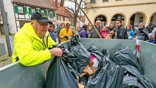 Organisator Wolfgang Röckle wuchtet einen vollen Müllsack in den Container. Foto: Simon Granville