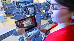Eine Mitarbeiterin scannt mit einem Tablet QR-Codes an den Schussspulen einer Webmaschine. Auch in modernen Fabriken spielt der freie Datenfluss eine wichtige Rolle. Foto: dpa