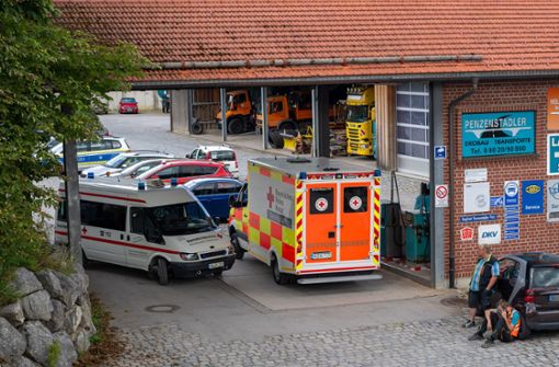 Ein Krankenwagen steht in der Einfahrt eines Unternehmens. Bei einem Arbeitsunfall in einer Entsorgungsfirma in Oberbayern sind drei Männer in einem Kanalsystem ertrunken. Foto: dpa/Peter Kneffel