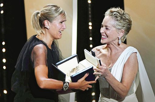 Die Regisseurin Julia Ducournau (li.) und die  Gratulantin Sharon Stone können es kaum fassen: Nach 28 Jahren gewinnt   wieder eine Frau die Goldene Palme. Foto: AFP