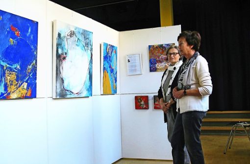 Hermine Neuschwander (rechts) und Inge Hoppmann mit Arbeiten von Ursula Fleig. Die drei Künstlerinnen  gehören zur  Botnanger Malgruppe. Foto: Susanne Müller-Baji