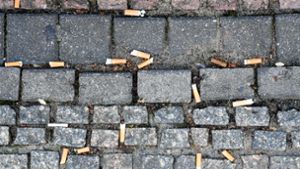 Zahlreiche auf den Boden geworfene Zigarettenstummel liegen auf dem Pflaster des Gendarmenmarktes in Berlin. Weltweit werden Schätzungen zufolge jedes Jahr 4,5 Billionen Zigaretten in die Umwelt geworfen. Foto: dpa/Jens Kalaene