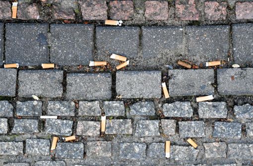 Zahlreiche auf den Boden geworfene Zigarettenstummel liegen auf dem Pflaster des Gendarmenmarktes in Berlin. Weltweit werden Schätzungen zufolge jedes Jahr 4,5 Billionen Zigaretten in die Umwelt geworfen. Foto: dpa/Jens Kalaene